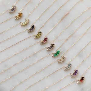 18K gold plated necklace set with diverse 12 birthstones fan pendants on marble background