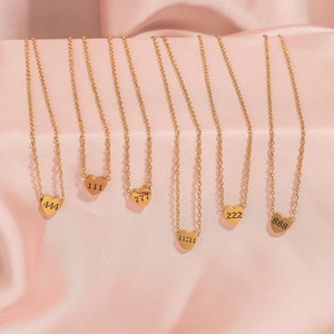 Golden heart pendant necklaces with 11:11 and angel numbers on pink satin background