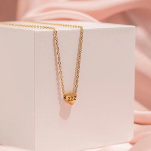 Golden heart pendant necklace featuring 222 engraving on a delicate minimalist chain