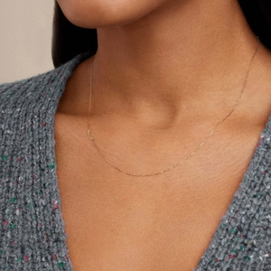 Detail shot of a minimalist gold-plated initial C pendant necklace on cable chain