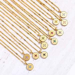 Macro detail of twelve gold disc pendants with star patterns and colorful birthstones