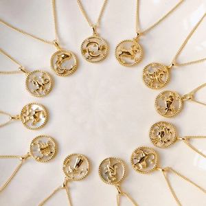 Collection de douze colliers zodiaque dorés avec détails en nacre et cristaux