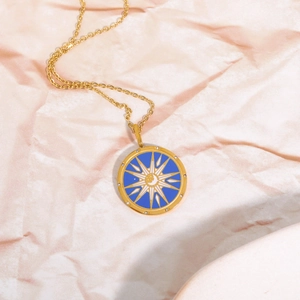Detail of gold tarot necklace with blue enamel sun pendant and cubic zirconia stones