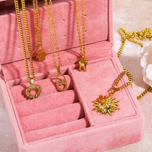 Set de cinco collares dorados con colgantes de Mano de Fátima, sol y corazón en terciopelo