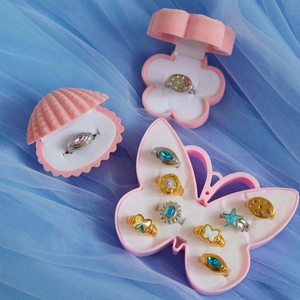Collection of colorful opal and rhinestone rings in shell-shaped pink velvet gift boxes