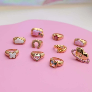 Detailed close-up of gold-plated rings with colorful opal hearts, butterflies and stars