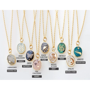Collection of 9 gold gemstone necklaces featuring butterfly, star, moon and heart charms