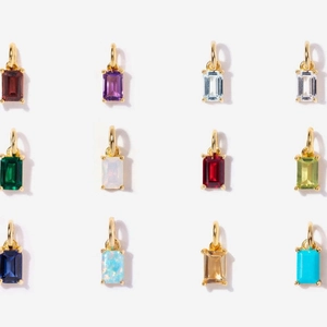 Detail view of twelve rectangular birthstone pendants in vibrant colors with gold plating