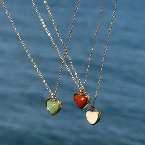 18K gold plated heart necklaces with red, green, and white stones on water background