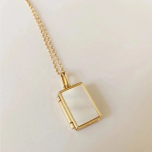 Dettaglio della collana con medaglione rettangolare dorato e inserto in madreperla