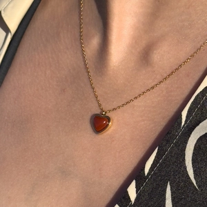 Elegant 18K gold-plated heart necklace with red agate pendant on female collarbone