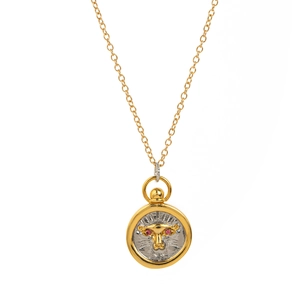 Close-up of gold and silver pendant with leopard head carving and red gemstone eyes