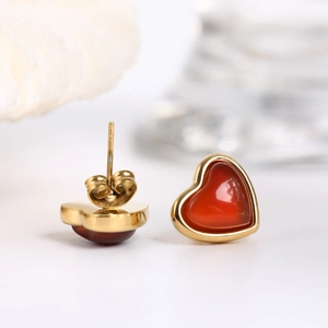Macro shot of heart-shaped red agate stud earrings with 18K gold plated metal edges