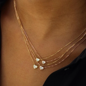Four-layer rose gold layered necklace featuring heart-shaped zircon pendants on a model