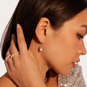 Close-up of safety pin earring with freshwater pearl on a model's ear profile