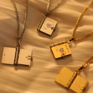 Collana con medaglione a forma di libro vintage in oro e argento con rilievo a farfalla