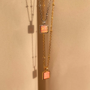 Dettagli di ciondoli quadrati in opale rosa con finiture in acciaio dorato e argento