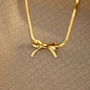 Macro shot of 18K gold plated stainless steel snake chain with a bow pendant