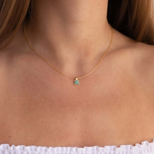 Dettaglio della collana con ciondolo a cuore in opale sul collo di una modella