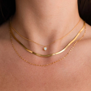 Dettaglio collana tripla in oro con ciondolo a cuore in opale e catena a serpente