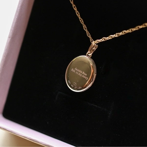 Vista macro del reverso del relicario ovalado de oro de 14K con grabado personalizado