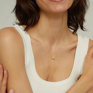 Vista detallada del collar de oro para mujer con perla blanca y colgante de circón