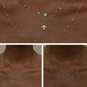 Detail of layered gold plated opal necklaces with blue stone accents on skin