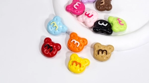 Makroansicht bunter Acrylbärenperlen mit m-Prägung für DIY-Schmuckherstellung