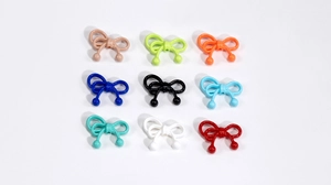 Macro view of colorful resin bow beads with glossy finish for DIY jewelry and crafts