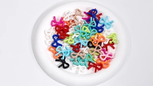 Macro shot of colorful resin bow beads for DIY jewelry and accessories making
