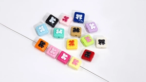 Close-up of colorful square acrylic bow beads with holes for DIY jewelry making