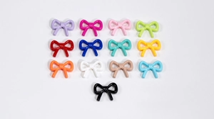 Macro shot of colorful bow-shaped resin beads for DIY jewelry and keychain crafts