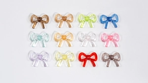 Detailed grid of twelve colorful transparent acrylic bow charms for DIY jewelry making