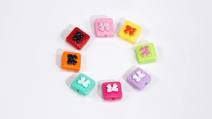 Top view of colorful square acrylic bow beads for DIY jewelry and phone chain making