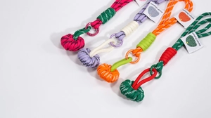 Detailed close-up of woven pumpkin charms for phones and keys in four vibrant colorways