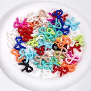 Colorful bow-shaped hollow resin beads for DIY jewelry and accessory making in a white bowl