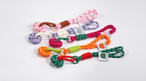 Detail of colorful braided rope keychains with metal rings and fashion fabric labels