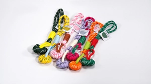 Detail of colorful braided rope keychains with spherical knots and fashion tags