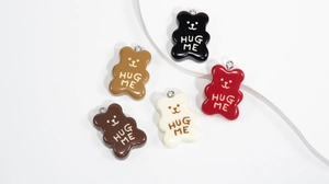Detailed view of colorful 3D bear charms in five shades with Hug Me lettering