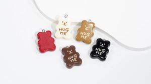 Macro shot of five colorful resin bear pendants with Hug Me text for DIY crafts