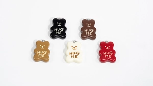 Close-up of colorful resin bear charms with Hug Me text for DIY jewelry making