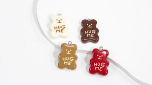 Close-up of resin cartoon bear charms in four colors with HUG ME text and metal rings