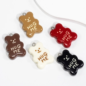 Colorful cartoon bear pendants with Hug Me text on a white display stand for DIY jewelry