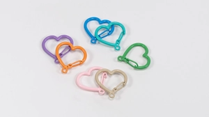 Dettaglio di fibbie a molla colorate a forma di cuore in varie finiture metalliche