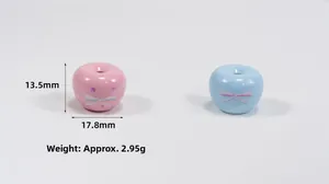 Detail view of pink and blue apple-shaped acrylic beads with bow and star patterns
