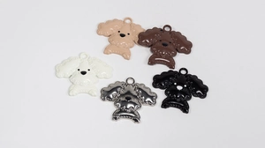 Close-up of five glossy resin poodle charms in brown, beige, black and metallic silver