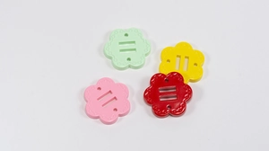Dettaglio di ciondoli a fiore a quattro fori colorati per catene telefoniche DIY