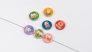 Close-up of double-sided cartoon dog and dessert printed beads for DIY jewelry making