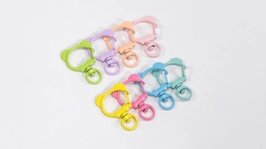 Macro detail of colorful bear-shaped alloy lobster clasps with bow decoration for DIY crafts