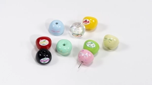 Macro shot of colorful apple-shaped acrylic beads with printed patterns for DIY crafts